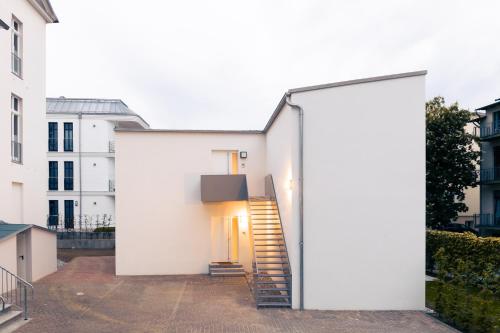 a white house with stairs leading up to it at OSTKÜSTE - Nadler Hof Design Apartments in Ahlbeck