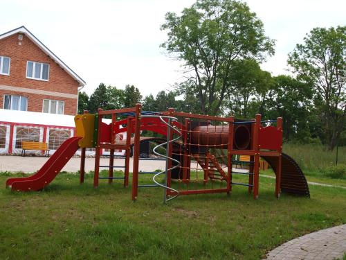 a playground with a slide in the grass at Guest House Kalnu pūpoli in Šengeida