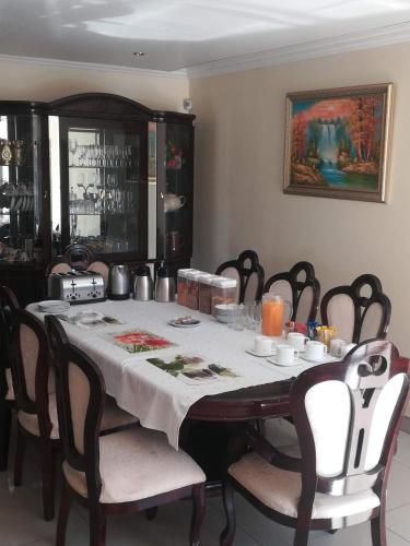 a dining room table with a white table cloth and chairs at Lalela House in Johannesburg