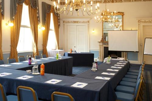 a set of tables in a room with a screen at Best Western Lichfield City Centre The George Hotel in Lichfield