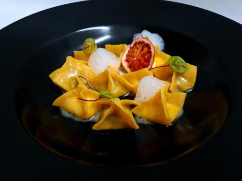 a plate of food with pineapple and a grapefruit at Hotel & SPA L'Antico Forziere in Deruta