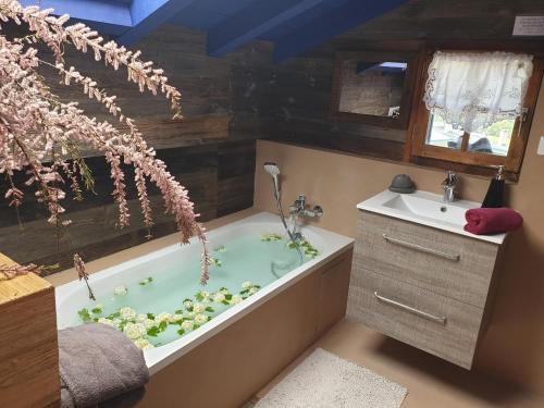 a bathroom with a bath tub with flowers in it at Le Petit Nid d'Amour, Propriétés Mont Amour in Montriond
