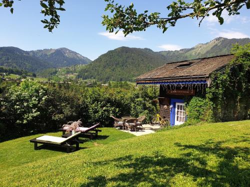 a house with a picnic table and benches in the grass at Micro-lodge, Le Petit Nid d'Amour in Montriond