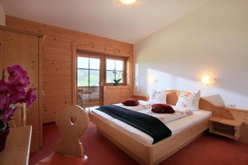 Schlafzimmer mit einem Bett mit weißer Bettwäsche und einem Fenster in der Unterkunft Gasthaus Obergaisberg in Kirchberg in Tirol