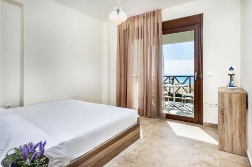 a bedroom with a bed and a view of the ocean at Sunset Villas in Possidi