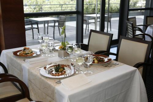 a table with plates of food and wine glasses at Montebelo Viseu Congress Hotel & Spa in Viseu