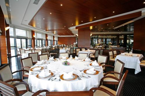 a large dining room with white tables and chairs at Montebelo Viseu Congress Hotel & Spa in Viseu