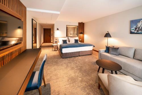 a hotel room with a bed and a couch at Luxury Hotel Riva in Malinska