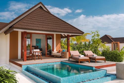 a swimming pool in front of a villa at VARU by Atmosphere - Premium All Inclusive with Free Transfers in North Male Atoll