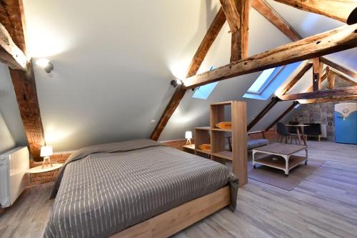 Ένα ή περισσότερα κρεβάτια σε δωμάτιο στο LOFT SOUS LES COMBLES - LOFT UNDER THE RAFTER