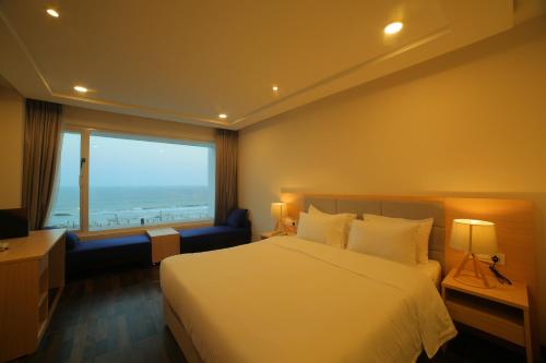 a hotel room with a bed and a large window at Bay View Hotel Vizag in Visakhapatnam