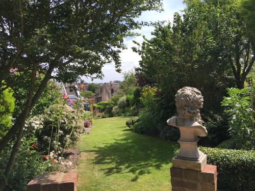 a statue sitting in the middle of a garden at Anne’s House in Hastings