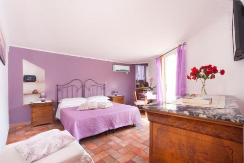 a bedroom with a bed with a purple wall at Sorrento Marida Rooms in Sorrento