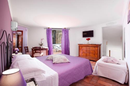 a bedroom with three beds and purple curtains at Sorrento Marida Rooms in Sorrento