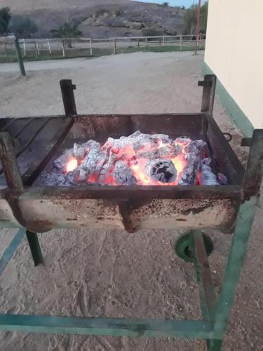 a grill that is sitting in a field at Augrabies De Oude Stoor Guesthouse in Augrabies