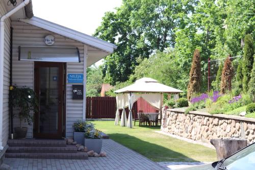 a small building with a table and an umbrella at Nileja in Vilnius