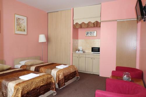 ヴィリニュスにあるNilejaのベッド2台とキッチンが備わるホテルルームです。