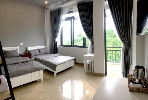 una camera con due letti e una grande finestra di Grey House a Da Lat