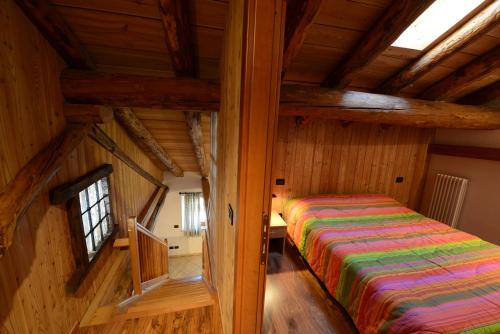 a bedroom with a bed in a room with wooden walls at Vieilles Maisons D'Introd in Introd
