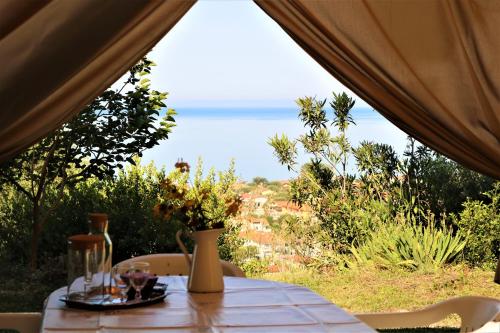 einen Tisch in einem Zelt mit Meerblick in der Unterkunft Antico Portale in Ascea