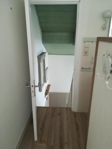 an attic room with a hallway with a door and wooden floors at Studio le Memagne in Lacuisine