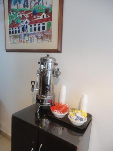 a table with a coffee machine on top of a cabinet at Hotel Casa Sarita in Bogotá