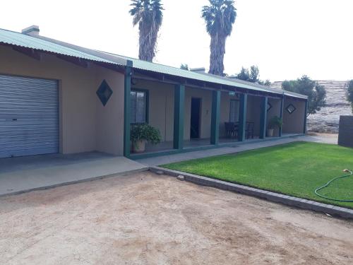 a house with a garage and a yard at Augrabies De Oude Stoor Guesthouse in Augrabies