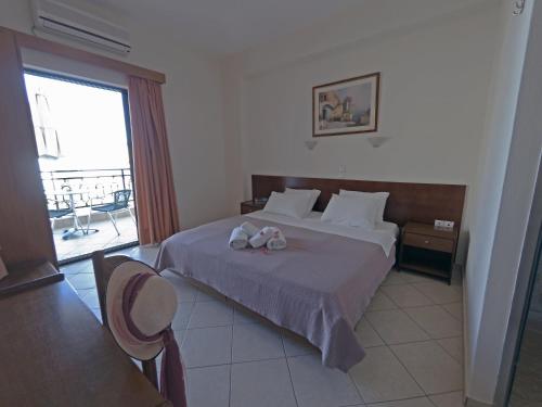 a bedroom with a bed with two towels on it at Hotel Loukas Vrachos in Paralia Vrachou