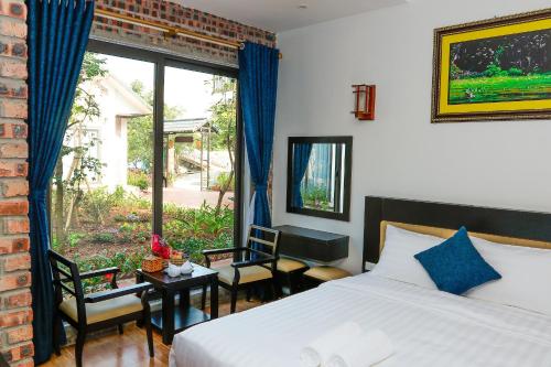 a bedroom with a bed and a large window at Tam Coc Golden Rice in Ninh Binh