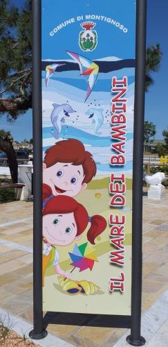 a sign for a beach with two girls on it at Appartamento ADRIANA in Cinquale