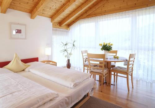 a bedroom with a bed and a table with chairs at Residence Walder in Falzes