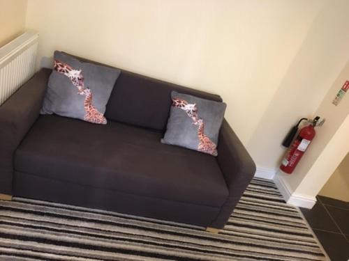 a couch in a room with two pillows on it at The Winter Garden Suites in Blackpool