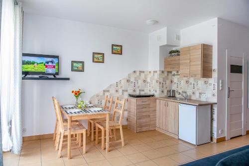 uma cozinha e sala de jantar com mesa e cadeiras em Family Homes - Apartamenty Vento em Władysławowo