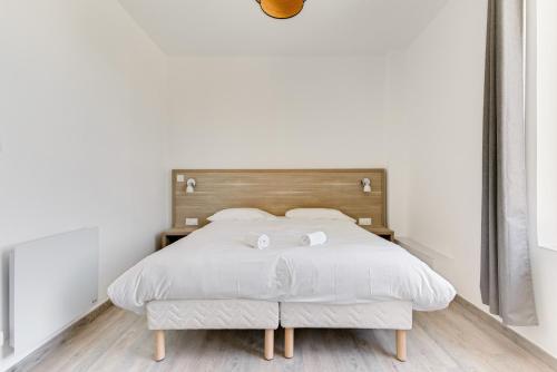 a bedroom with a white bed with two towels on it at Hôtel de la Citadelle in Sisteron
