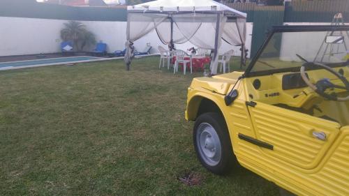 a yellow jeep parked in a yard with a tent at Quinta Salinas - Puro Prazer in Aveiro