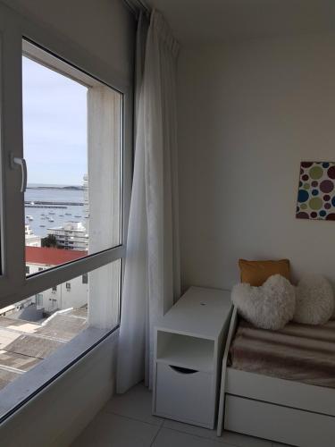 Habitación con ventana, sofá y mesa. en Apartment Peninsula, en Punta del Este