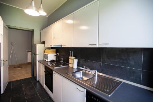 una cucina con mobili bianchi e un lavello di Chic and Freak Como a Como