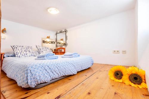 una camera da letto con un letto con girasoli sul pavimento di Original loft en Lavapiés a Madrid