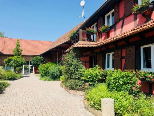 a building with flower boxes on the side of it at Les Authentics - Le Domaine d'Autrefois & Spa in Bolsenheim