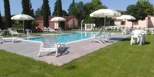 a pool with chairs and tables and umbrellas at Agriturismo Barbarino in Vinci