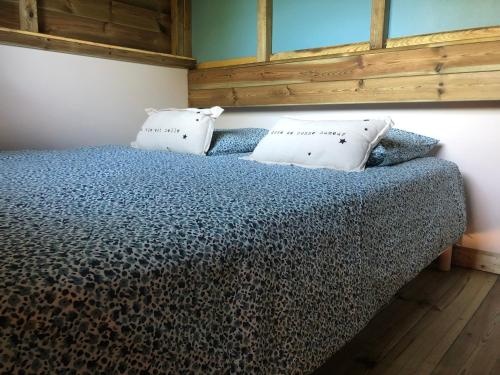 a bedroom with a bed with two pillows on it at Le domaine des hauts de canche Magnifique Tiny house avec Spa in Étaples