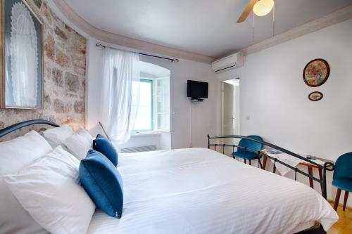 a bedroom with a large white bed with blue pillows at Villa Kuljis in Komiža