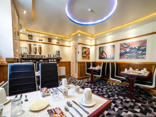 un restaurante con sillas y mesas en una habitación en Vegas Hotel en Londres