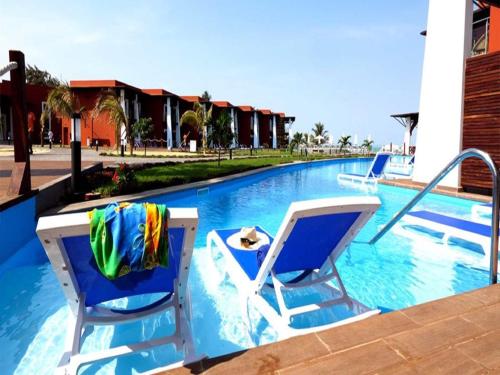 two chairs and towels on a swimming pool at African Princess Beach Hotel in Serekunda