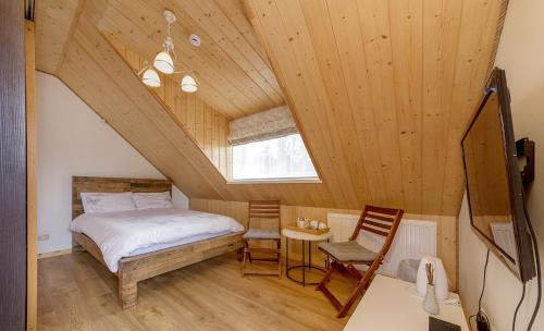 ein Schlafzimmer mit einem Bett und einem Stuhl in einem Zimmer in der Unterkunft Prie Lukos ezero in Trakai