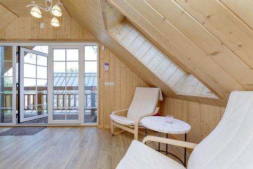 a attic room with two chairs and a table at Prie Lukos ezero in Trakai
