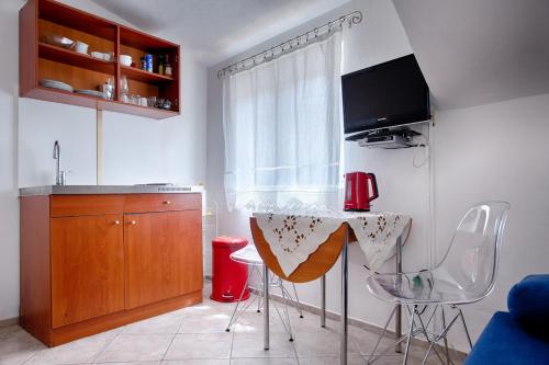 a kitchen with a table and chairs and a sink at Villa Kuljis in Komiža