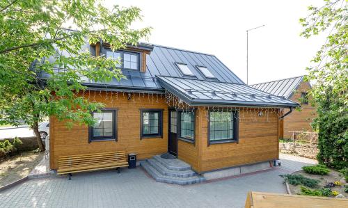 a wooden house with a porch and a bench at Prie Lukos ezero in Trakai