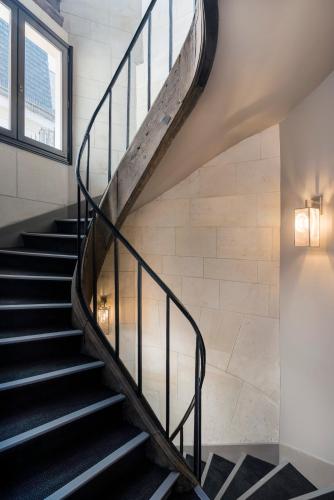 a staircase in a building with a glass railing at Hôtel Le Presbytère in Paris