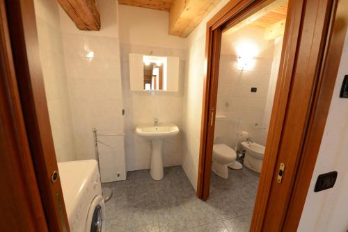 a bathroom with a sink and a toilet and a mirror at Vieilles Maisons D'Introd in Introd